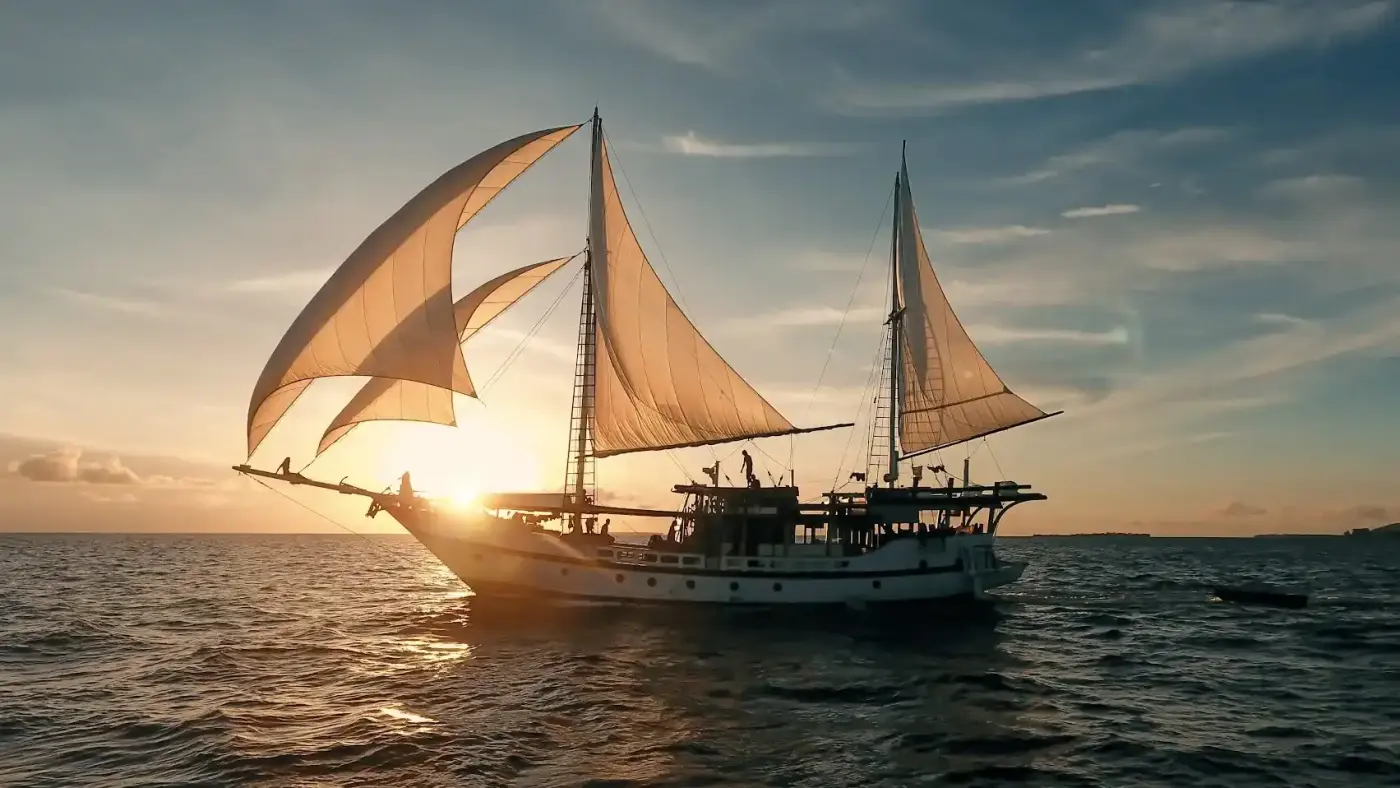Liveaboard phinisi sailing at golden hour